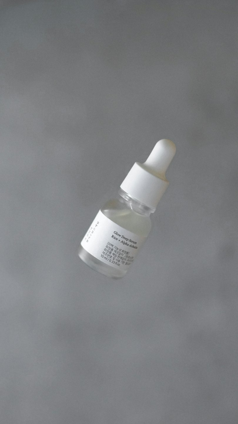 Glass dropper bottle with skincare serum floating mid-air.