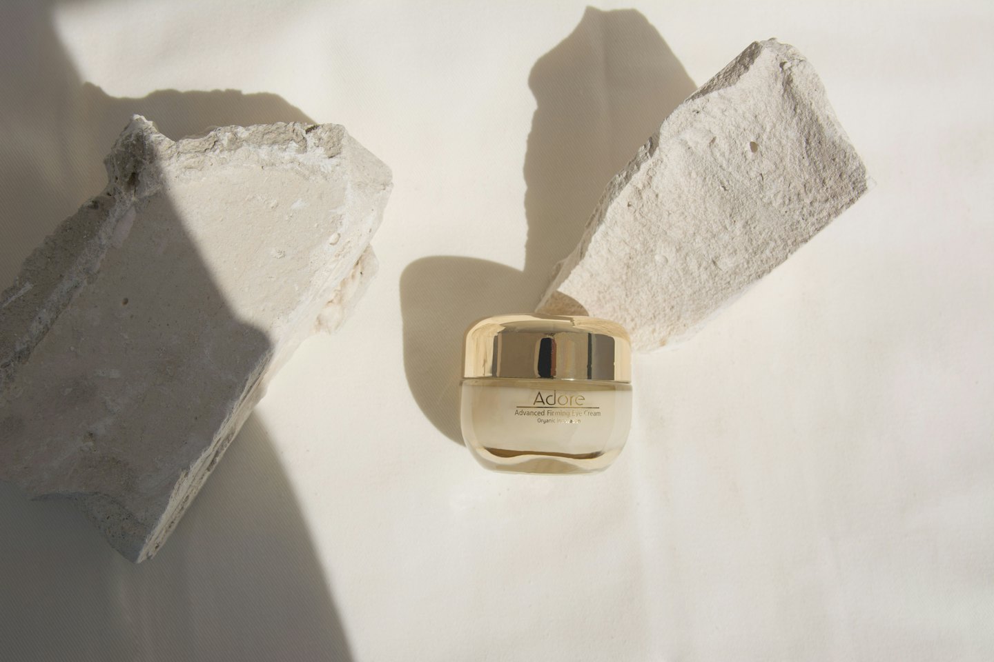 Adore Advanced Firming Eye Cream jar with grey stones.